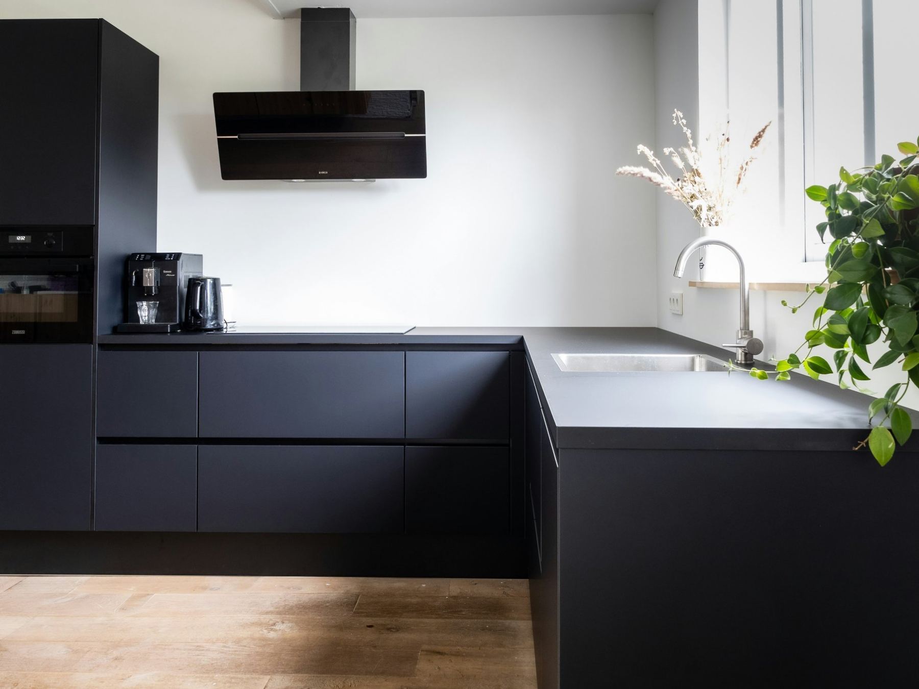 Kitchen with matte black cabinets and white walls
